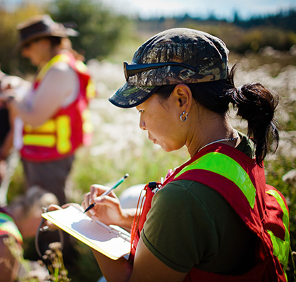 Three diamond-shaped photos showing a business meeting, a busy city highway with cars, and a field worker in safety gear taking notes.