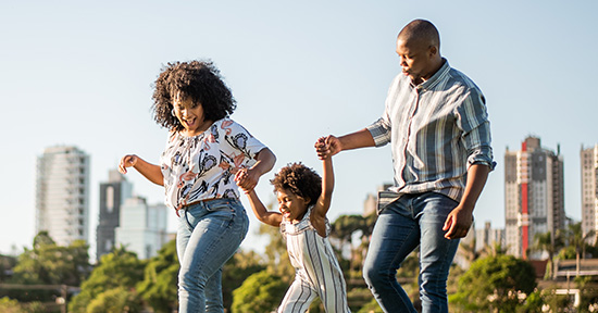A family walking hand in hand outdoors.