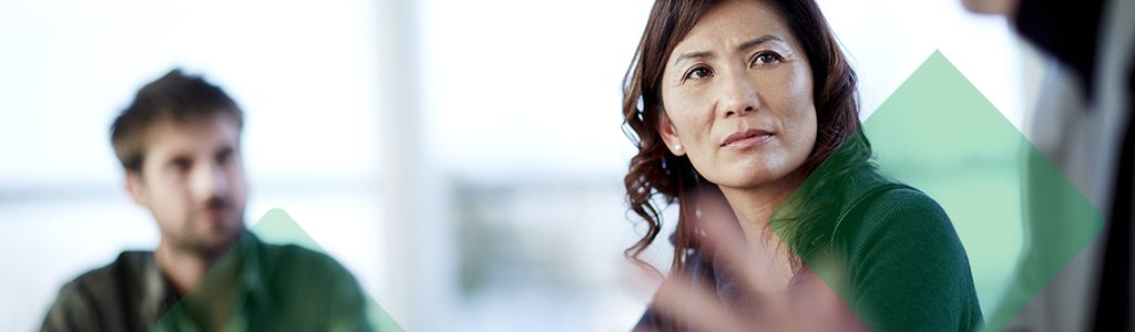 A woman listening attentively during a discussion in an office.