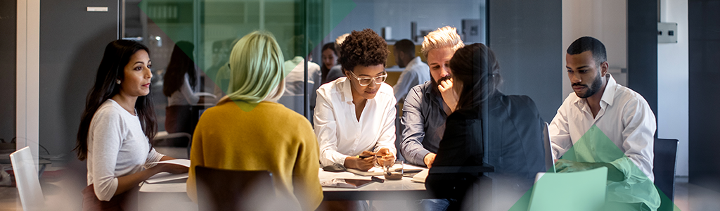 A diverse group of people collaborating around a table in a meeting room.