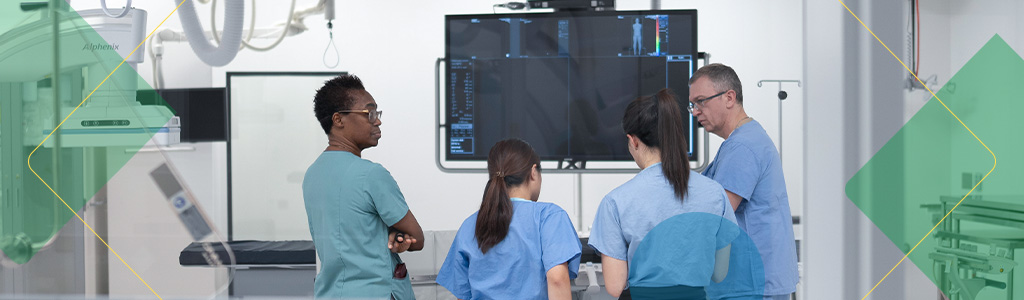 Medical staff discussing imaging results in a hospital procedure room.