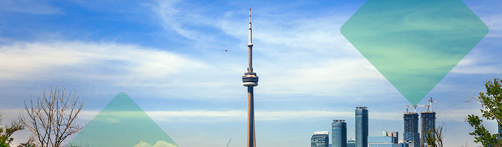 The Toronto skyline with the CN Tower under a blue sky.